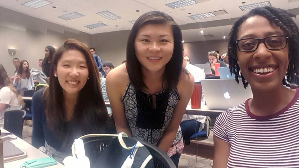 three girls looking at camera smiling in room