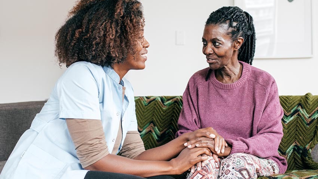 Female caregiver talking to an elderly woman