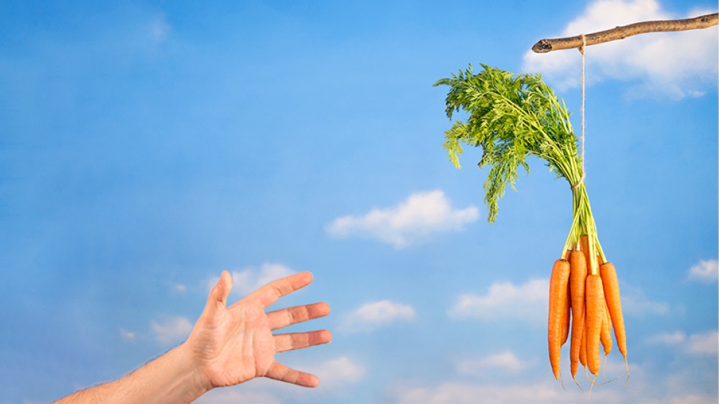 hand reaching for carrot sticks in air with blue sky background