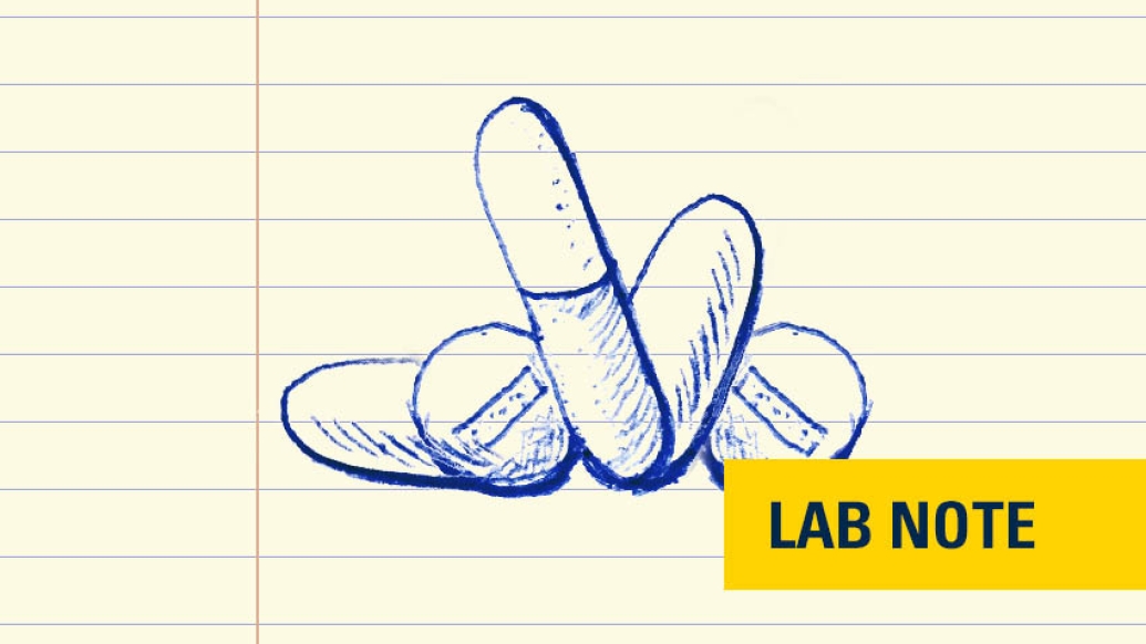 drawing of pills in blue ink with lab note written on bottom right in yellow and navy blue
