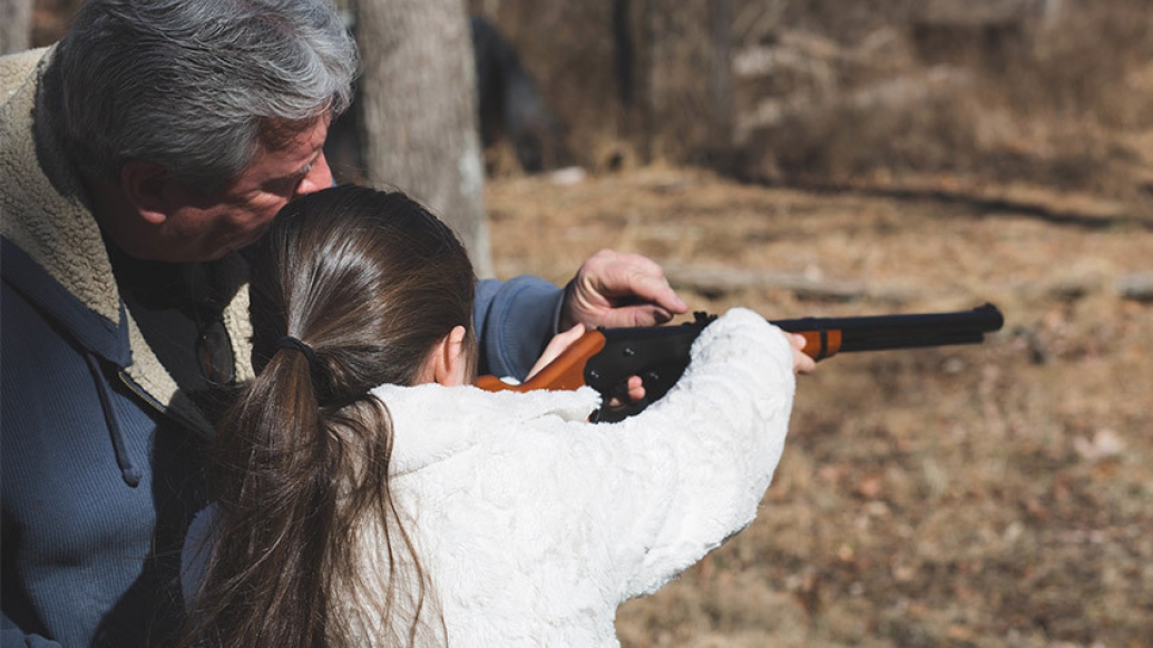 man girl shooting rifle