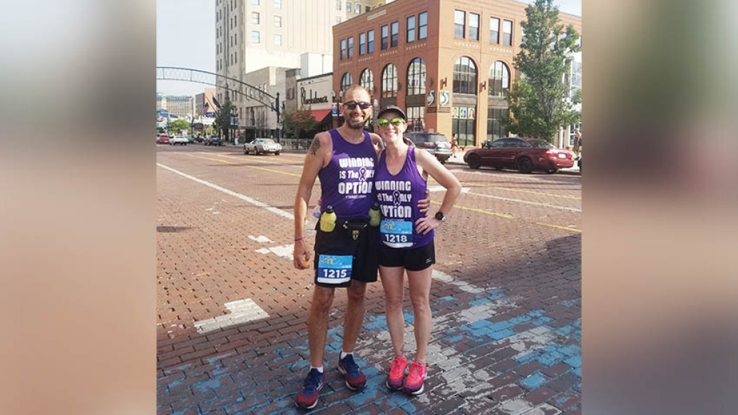 two runners standing next to each other on street in running gear