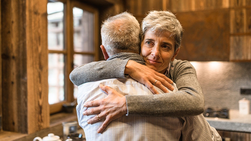 Senior couple hugging in kitchen