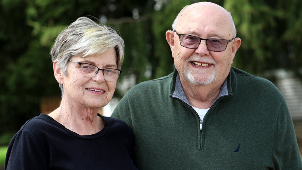 Senior couple standing outdoors smiling