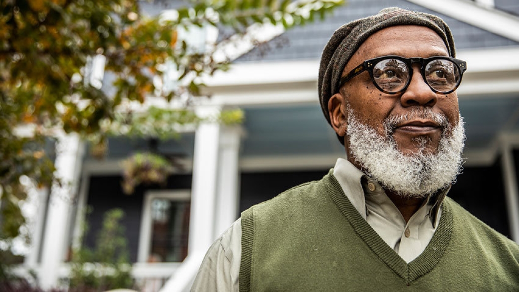senior man wearing glasses house in background