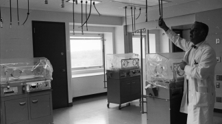 1969 photo of a doctor working in the NICU