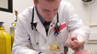 A medical student practices on a dummy
