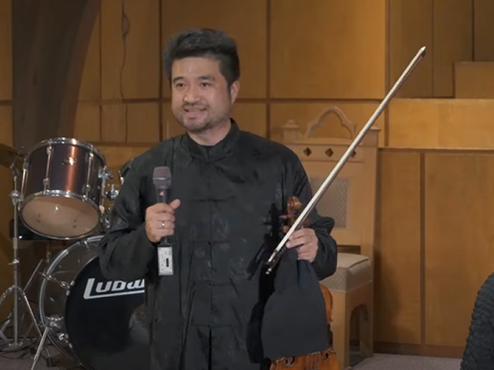 man holding a violin at a concert