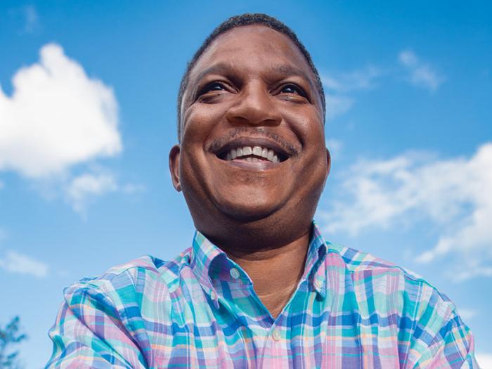 Andre smiles with the blue sky behind him
