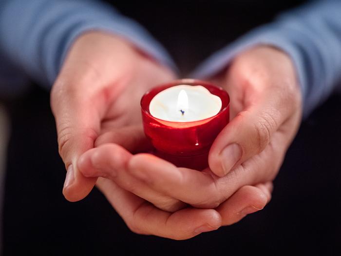 close up of woman holding a votive candle