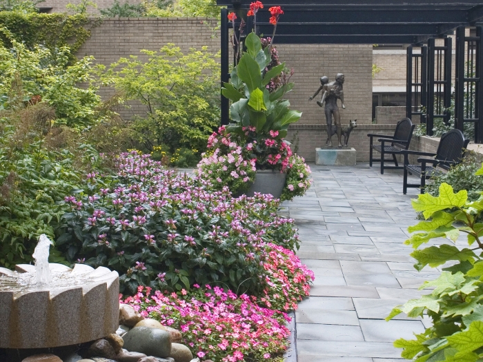 Garden with with fountain and paved pathway leading up to sculpture