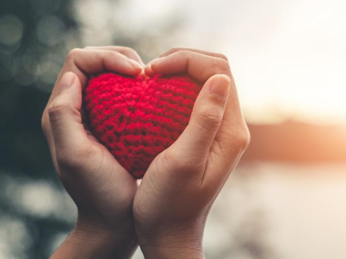 hands holding knitted red heart