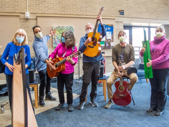 Bedside musicians stand together for photo with instruments