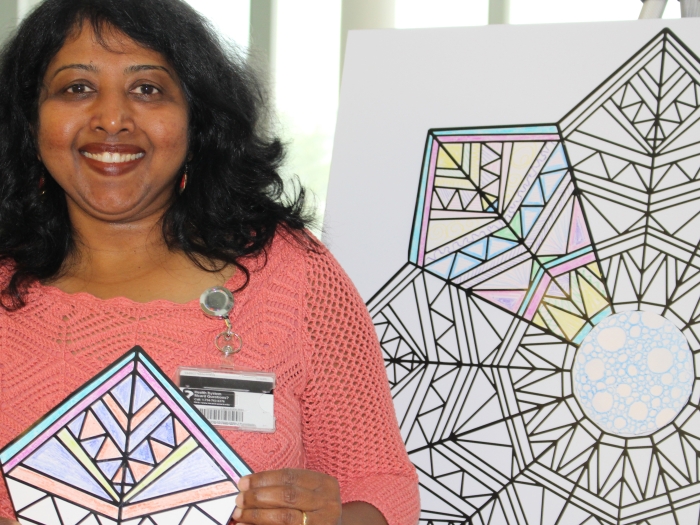 A volunteer holds up a completed coloring sheet
