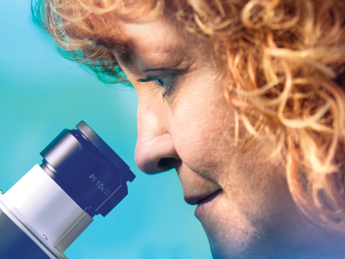 Dr. Lori Isom looking into a microscope