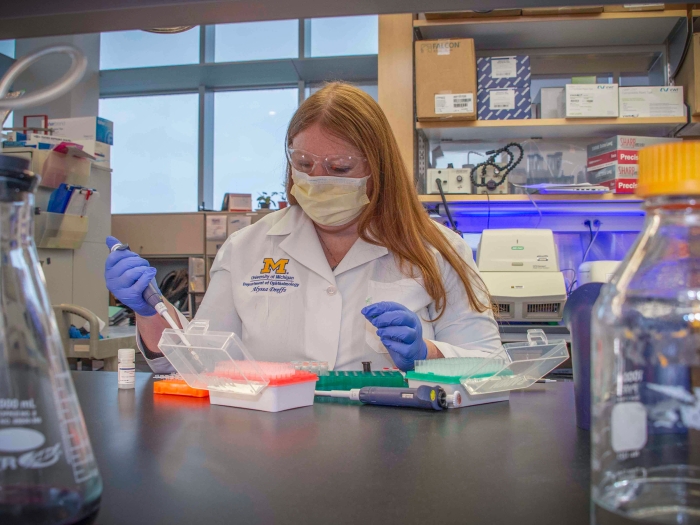 lab bench scientist white coat in lab doing experiment