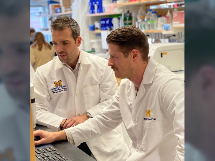 scientists together at computer in white coats