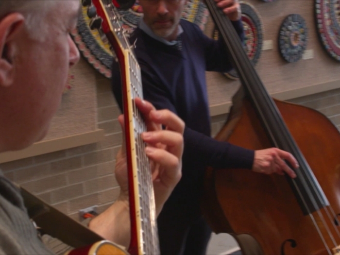 guitarists perform in front of the art display