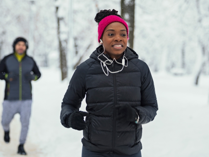 Man and women jogging ear buds on