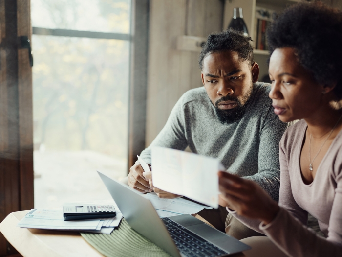 couple looking at paper work concerned at home