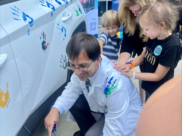 Mott doctor getting handprints during Hope on Wheels event 2023