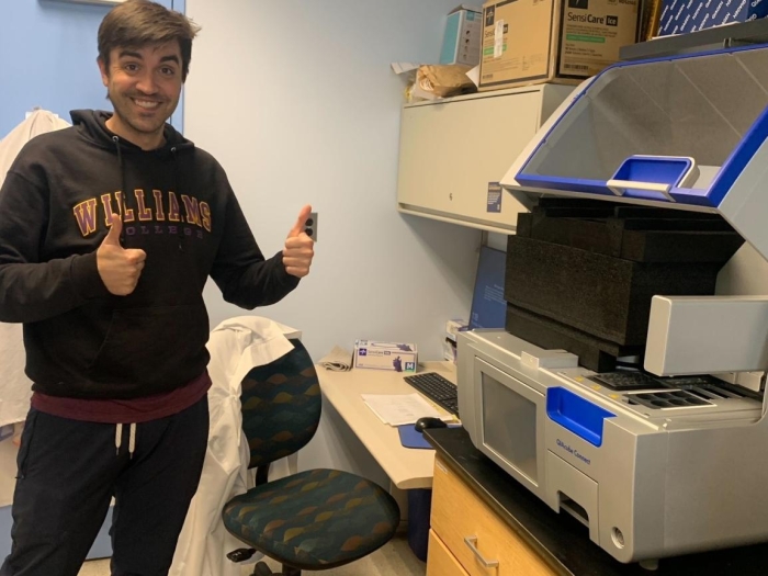 Dr. Wadden standing with the QIAcube in the Koschmann Lab.
