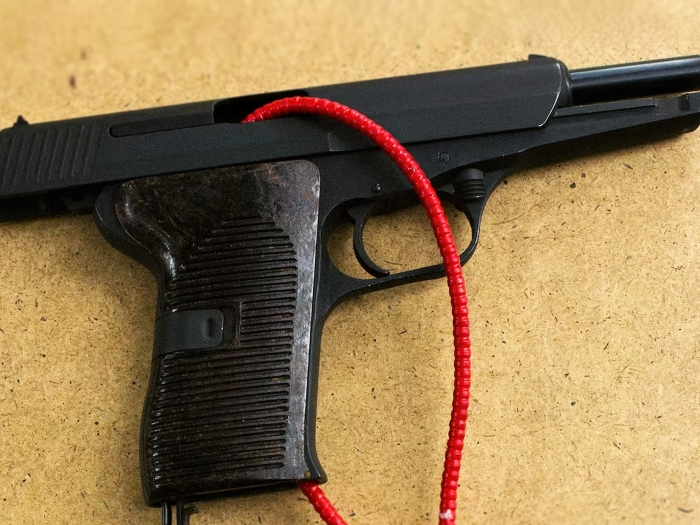 black gun on brown surface with red string