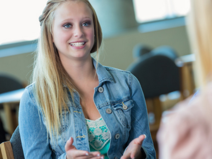 teen girl speaks with another girl