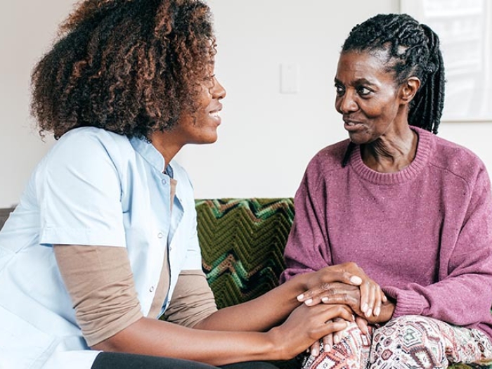 Female caregiver talking to an elderly woman