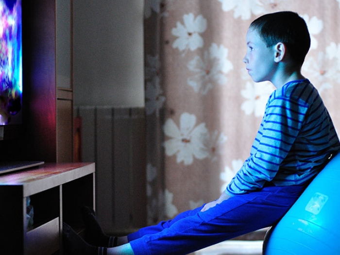 child sitting exercise ball tv