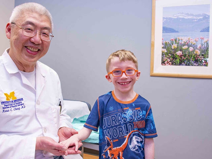 Hand surgeon standing next to pediatric male patient