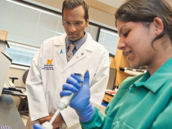 doctor and researchers in lab coat and white coat in lab looking at syringe injection