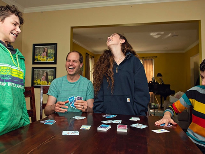 family laughing together at table with game