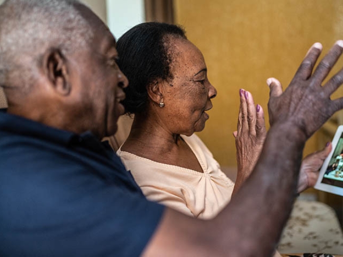 grandparents calling on an ipad for a video call with family waving hi