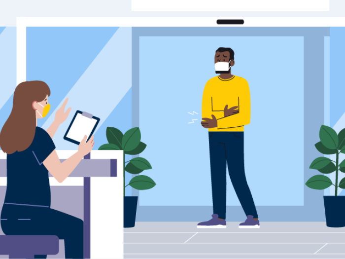 man holding arm in pain in emergency room with nurse with mask on