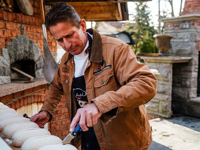 man slicing dough knife bread