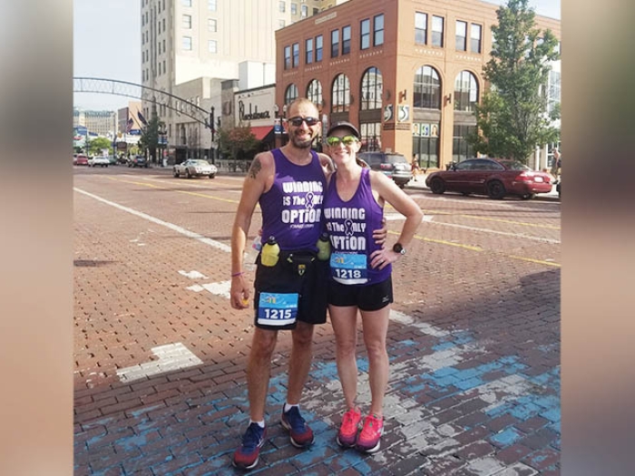 two runners standing next to each other on street in running gear