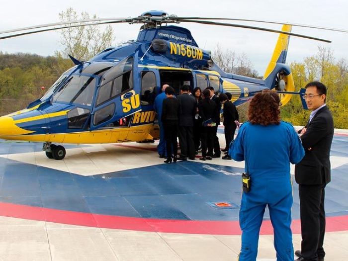 team standing outside in helicopter on helipad