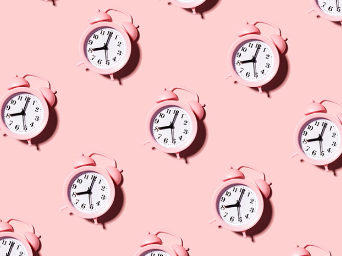 pink old school alarm clock in repetitive pattern