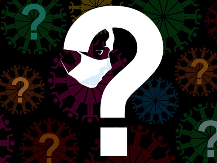 white big question mark with mask hanging off in black background with colored question marks floating