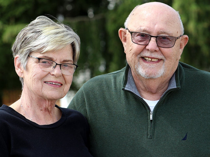 Senior couple standing outdoors smiling