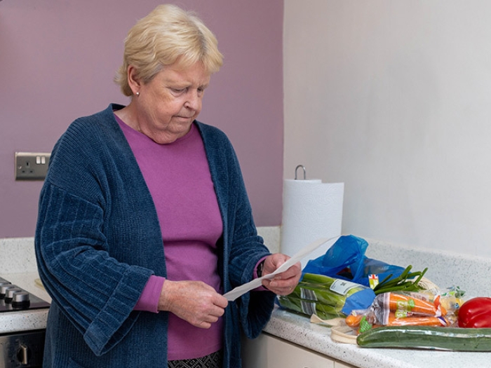 senior woman looking at receipt of groceries