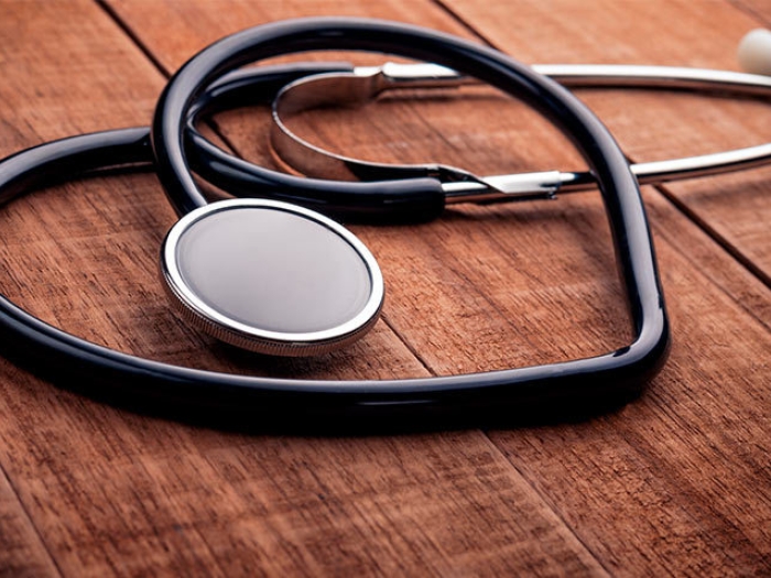 stethoscope in heart shape on wooden table