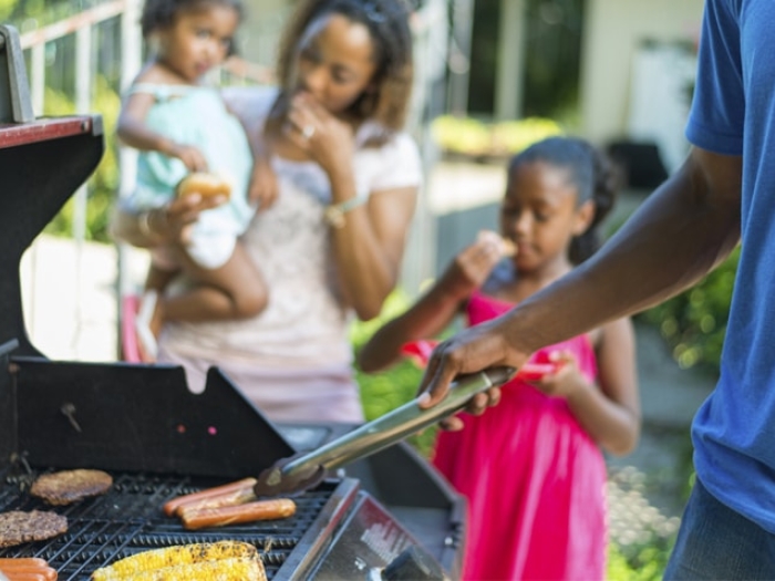 two kids outside barbequing with parents