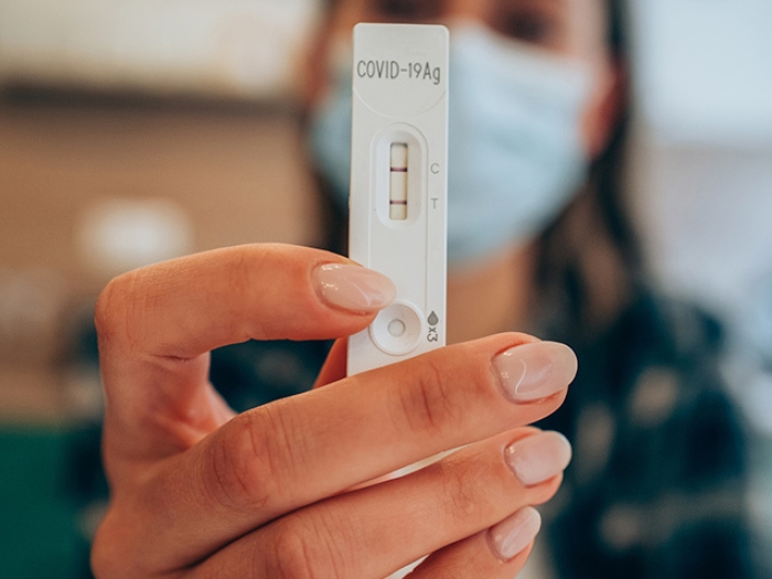 woman mask holding covid test