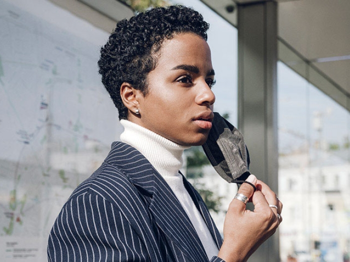 Woman in suit removing mask on bus