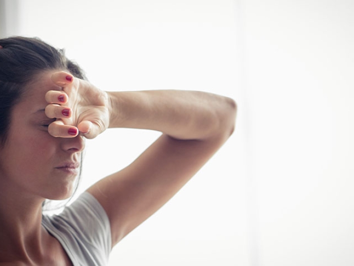Women with hand over forehead.