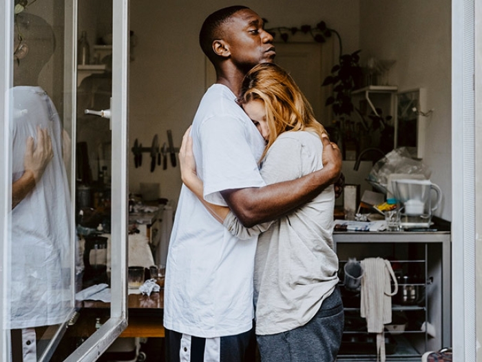 young man hugging woman in window
