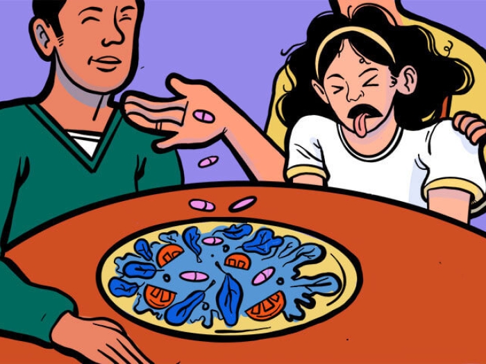 Father and daughter sitting at table. Girl making face at blue leafy tomato dish.
