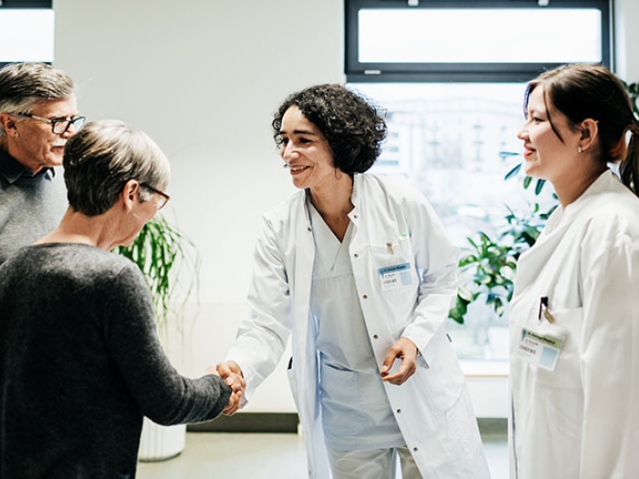 doctors shaking hand of patient in waiting room